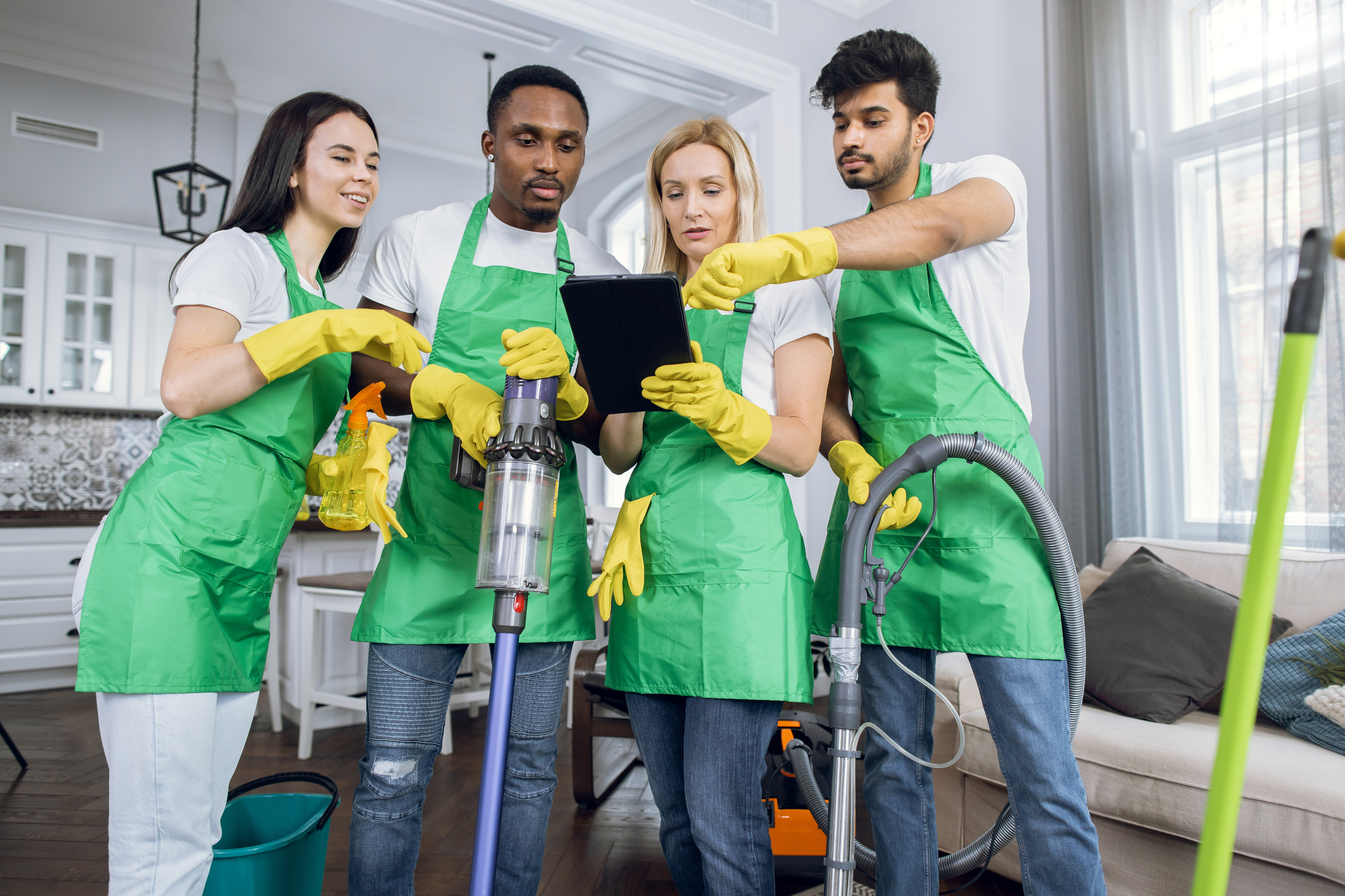 Smiling cleaning crew standing together in front of a brick wall