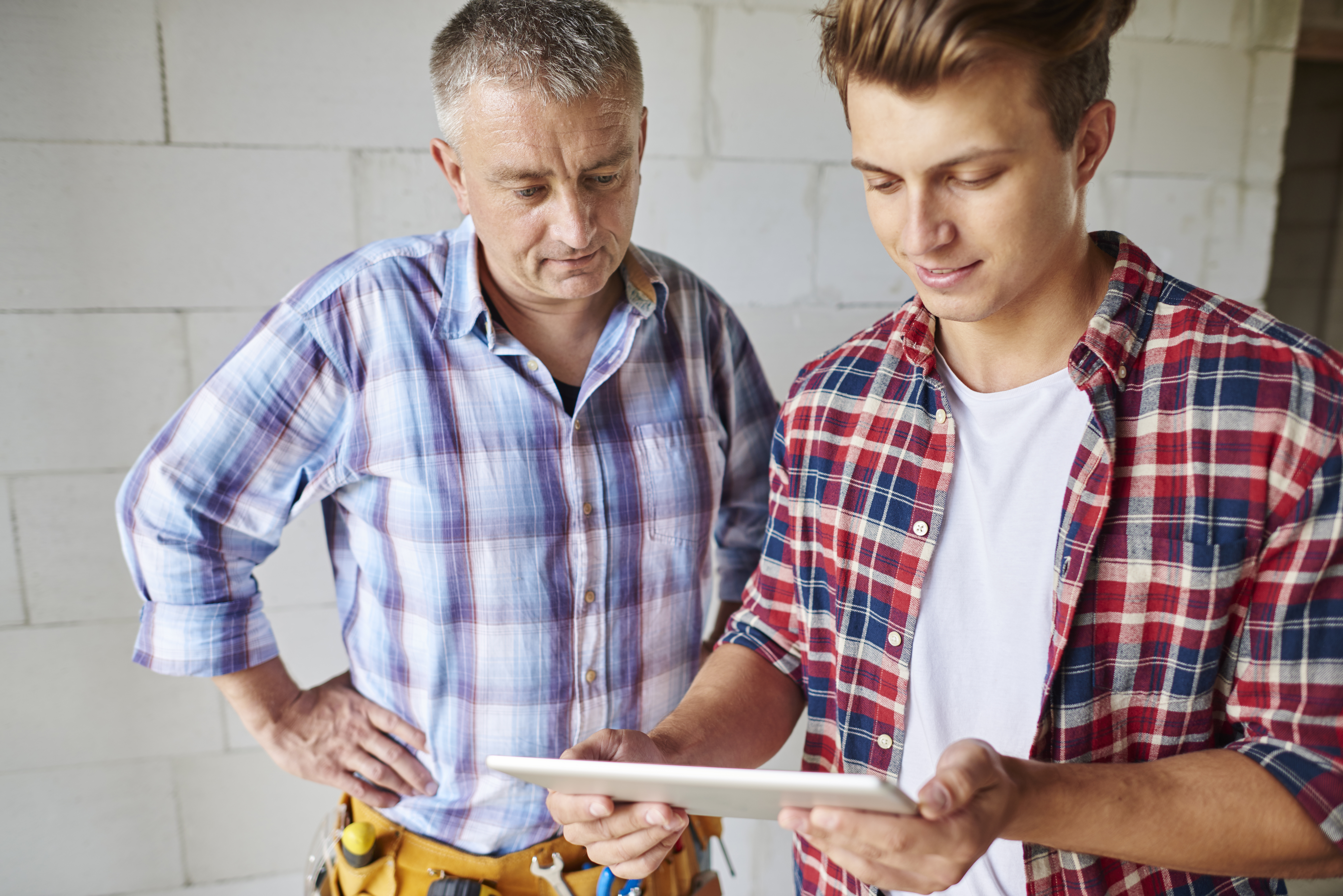 Family business owners reviewing a project on a tablet
